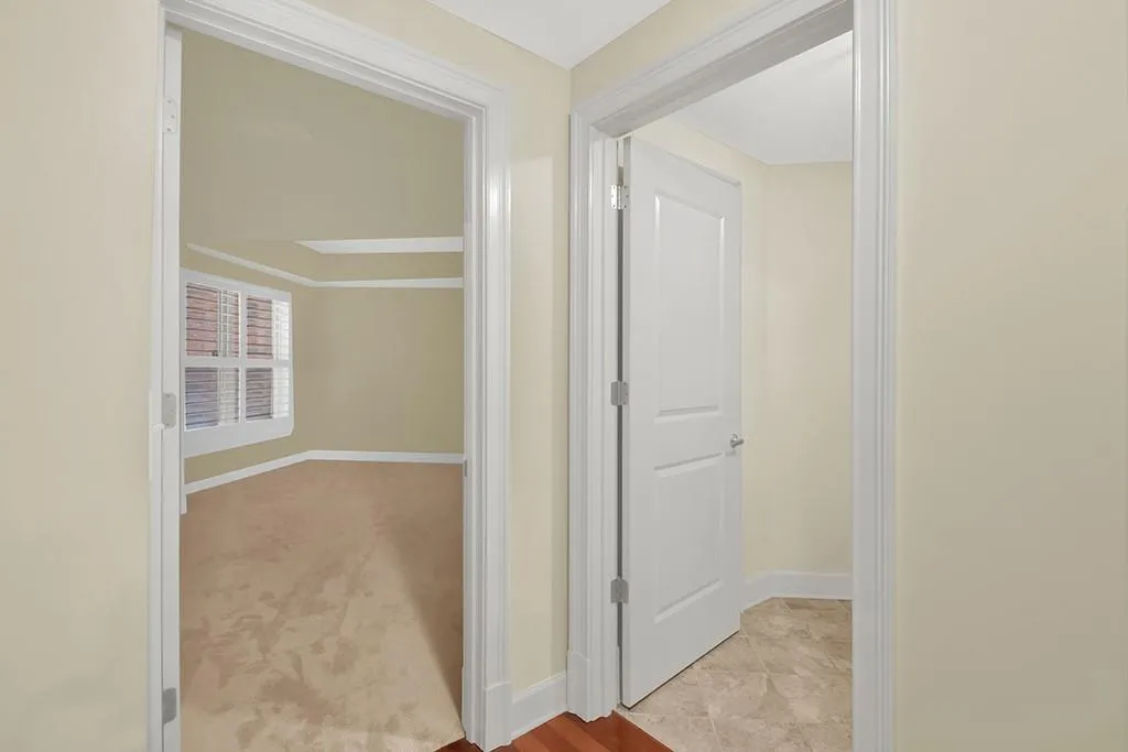 Hallway featuring light carpet