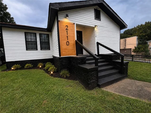 White siding exterior with a black trim roof and black-painted foundation