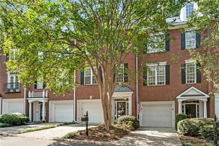 Brick exterior with white window trim and black louvered shutters
