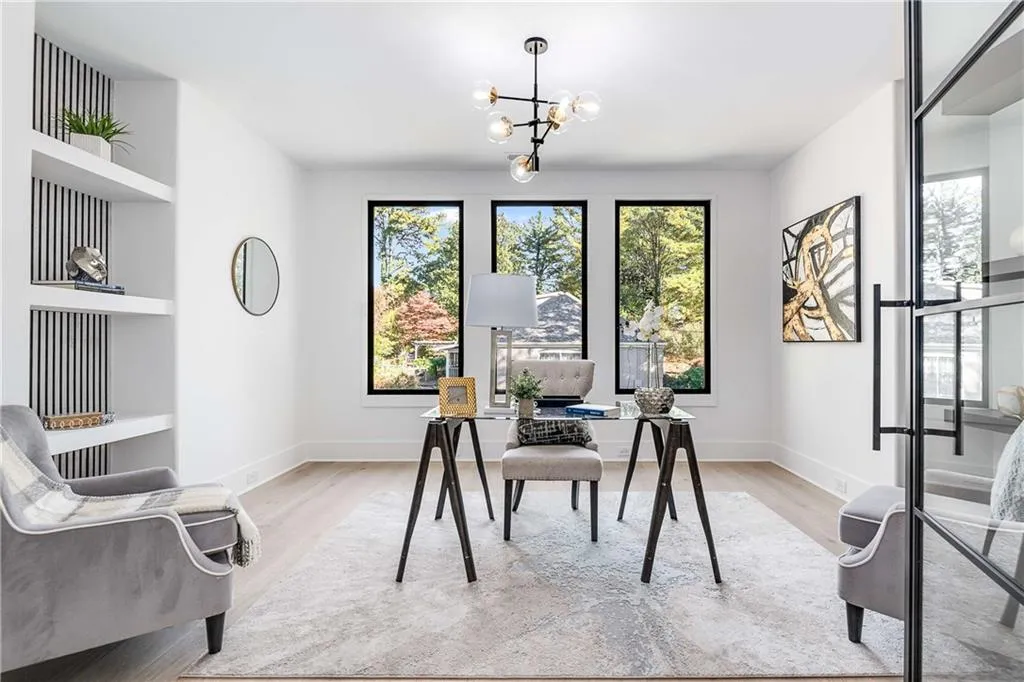 Home office with built in features, light wood-type flooring, and suspended lighting