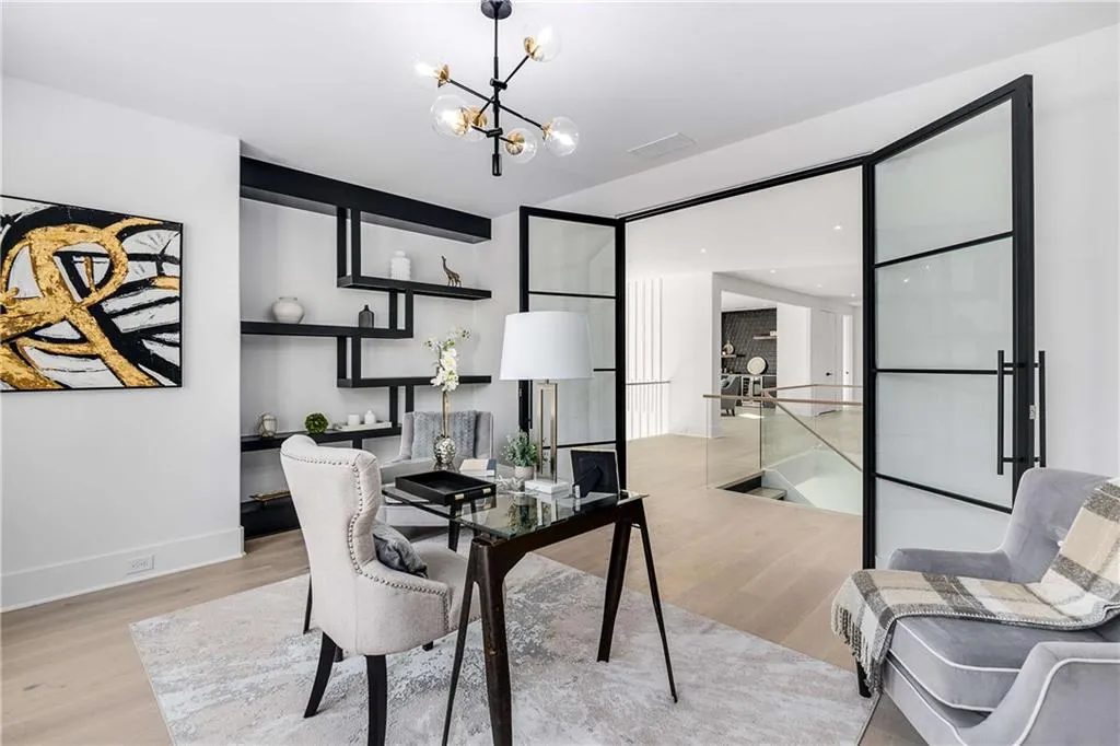 Home office with light wood finished floors and suspended lighting