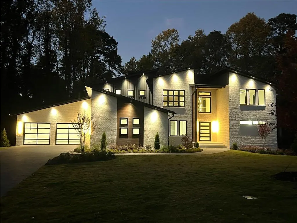 Contemporary house featuring driveway, a garage, and a front lawn