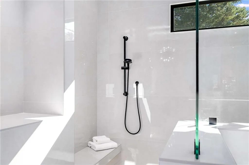 Full bathroom featuring vanity, a tile shower, and tile walls