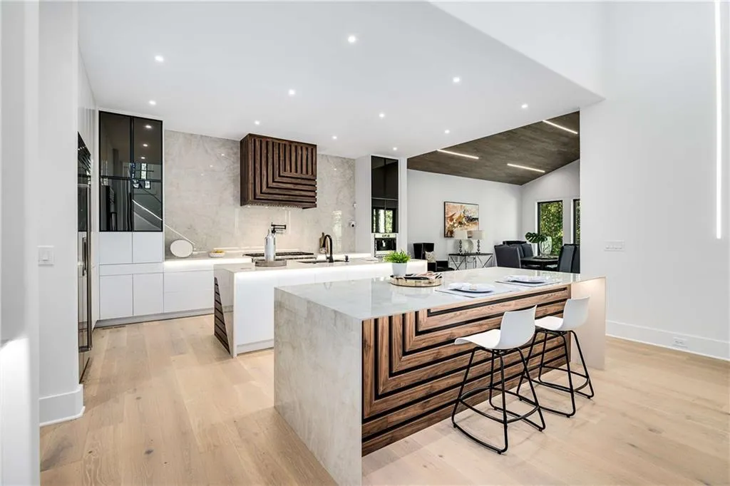 Kitchen featuring dual tone cabinetry, a kitchen island, light wood finished floors, recessed lighting, and a kitchen breakfast bar