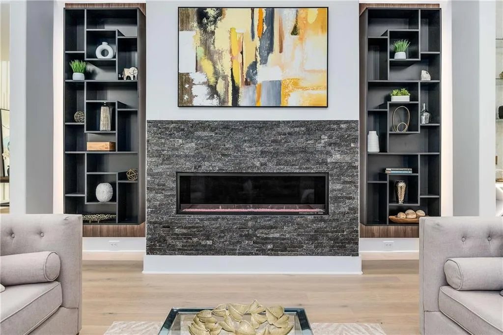 Living room featuring a fireplace, built in features, and wood finished floors