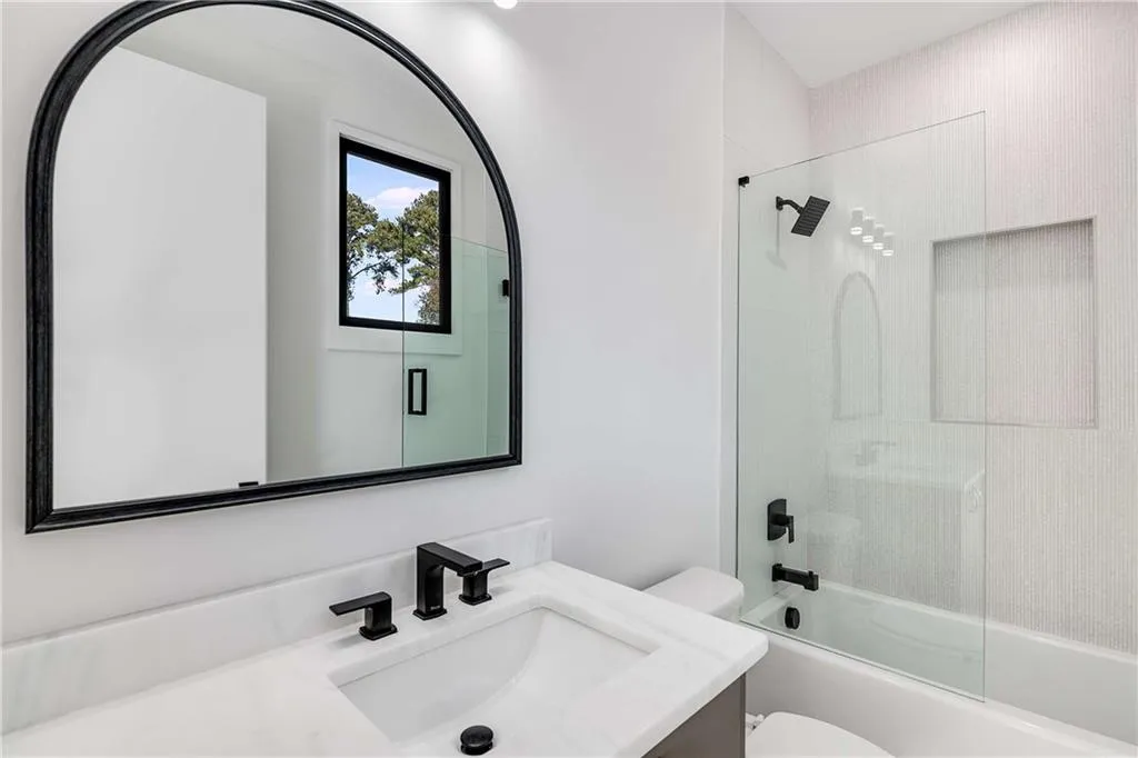 Full bath with vanity and combined bath / shower with glass door