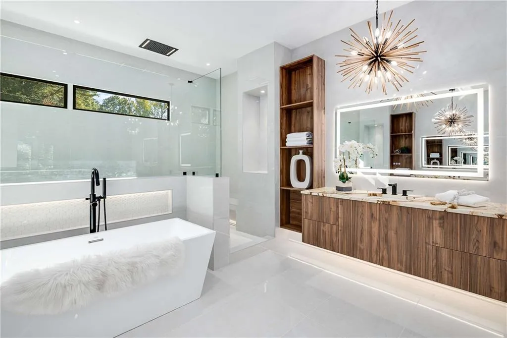 Full bathroom featuring a walk in shower, vanity, a soaking tub, suspended lighting, and light tile patterned flooring