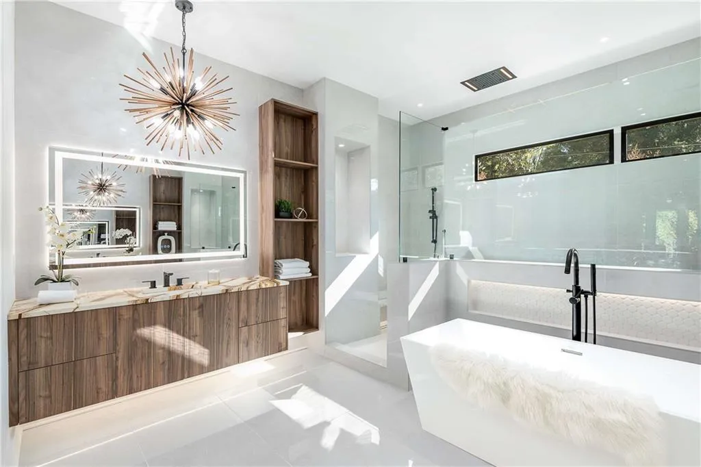 Bathroom with a walk in shower, vanity, suspended lighting, light tile patterned floors, and a freestanding tub
