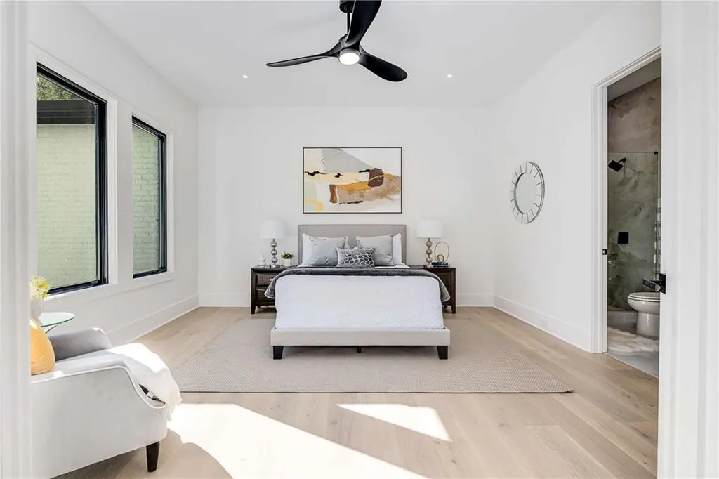 Bedroom with light wood-type flooring, a ceiling fan, connected bathroom, and recessed lighting