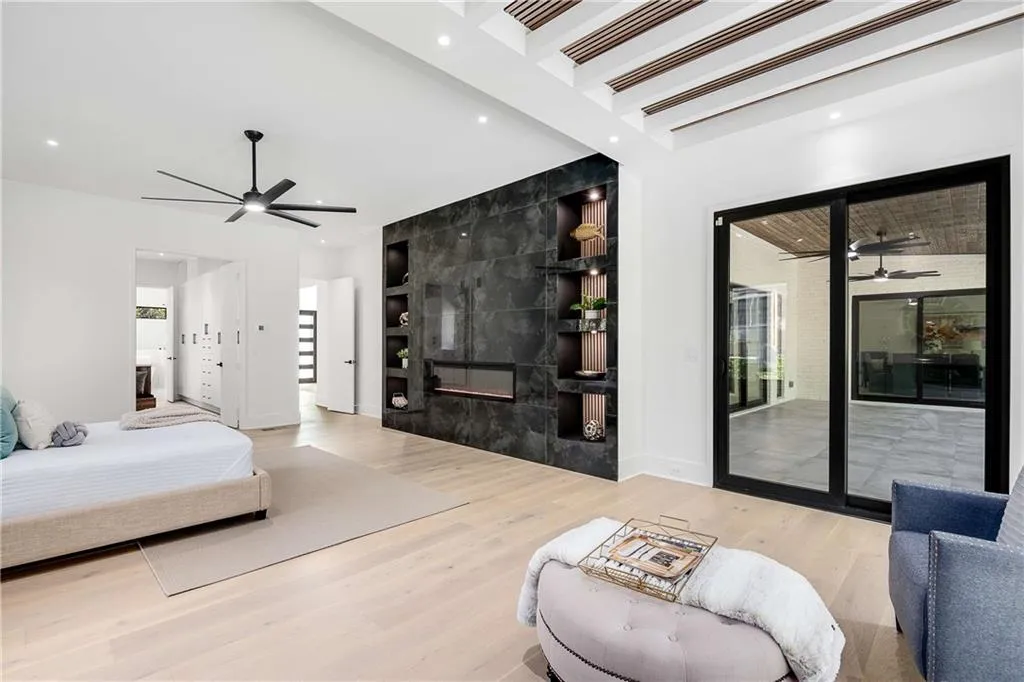 Bedroom with light wood-type flooring, a fireplace, recessed lighting, and access to outside