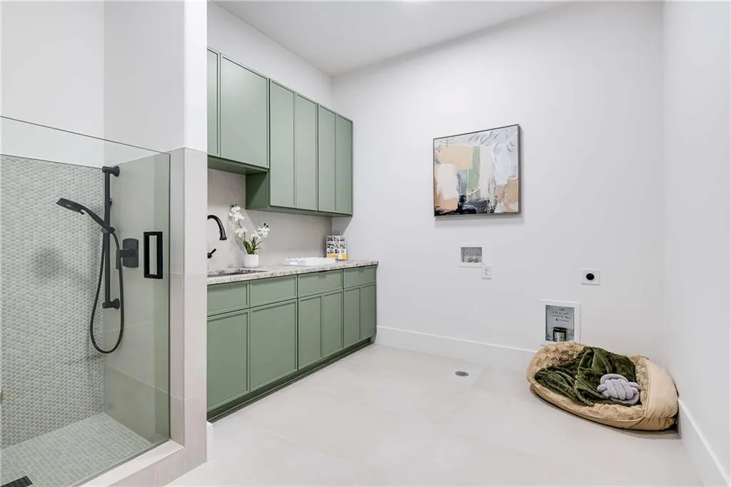 Laundry area with hookup for a washing machine, hookup for an electric dryer, cabinet space, and light tile patterned floors