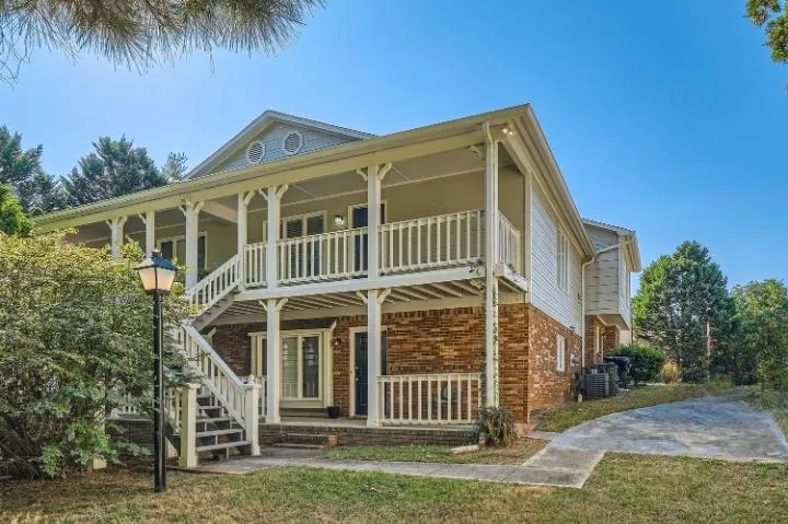 Two-story residence featuring a brick first level and light-colored siding on the second level