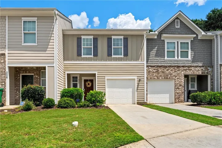 Exterior featuring vertical and horizontal siding, brick accents, and a single-car garage