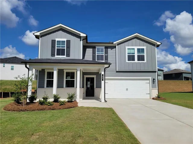 Two-story exterior with a covered porch, attached garage, and a concrete driveway