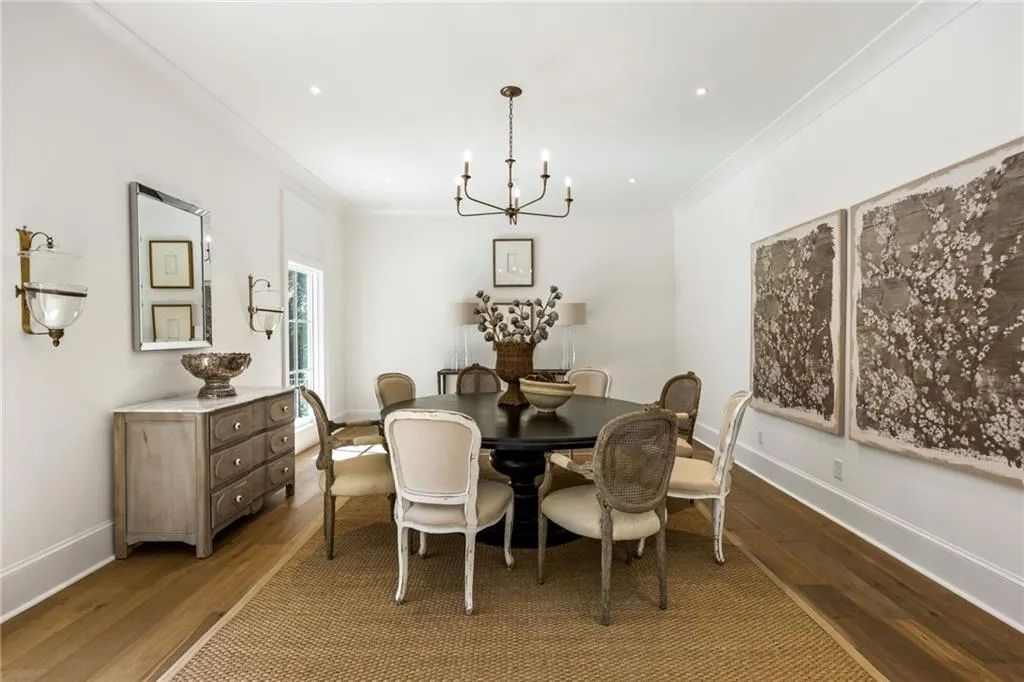 Dining area featuring wood-finish flooring, recessed ceiling lighting, a multi-arm chandelier, and crown molding