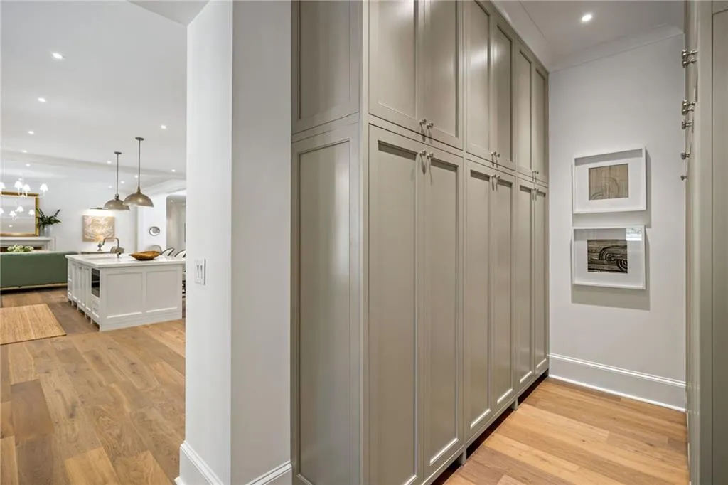 Full-height custom cabinetry with shaker-style doors and integrated hardware, wood-finish flooring, and recessed ceiling lighting