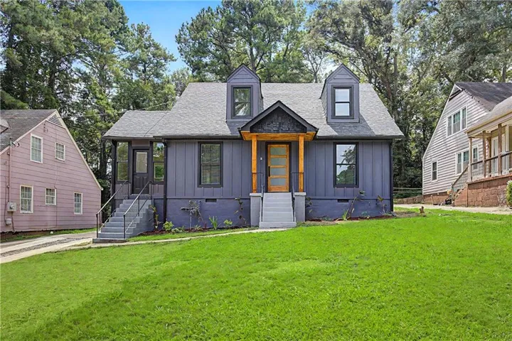 Vertical siding exterior with dormer windows, a covered entry porch, and a wood-finish front door