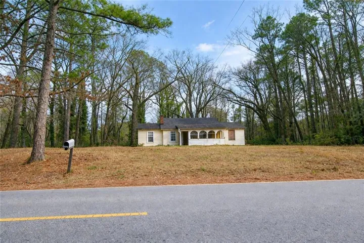Single-story residence featuring a brick chimney and a covered porch with arched openings