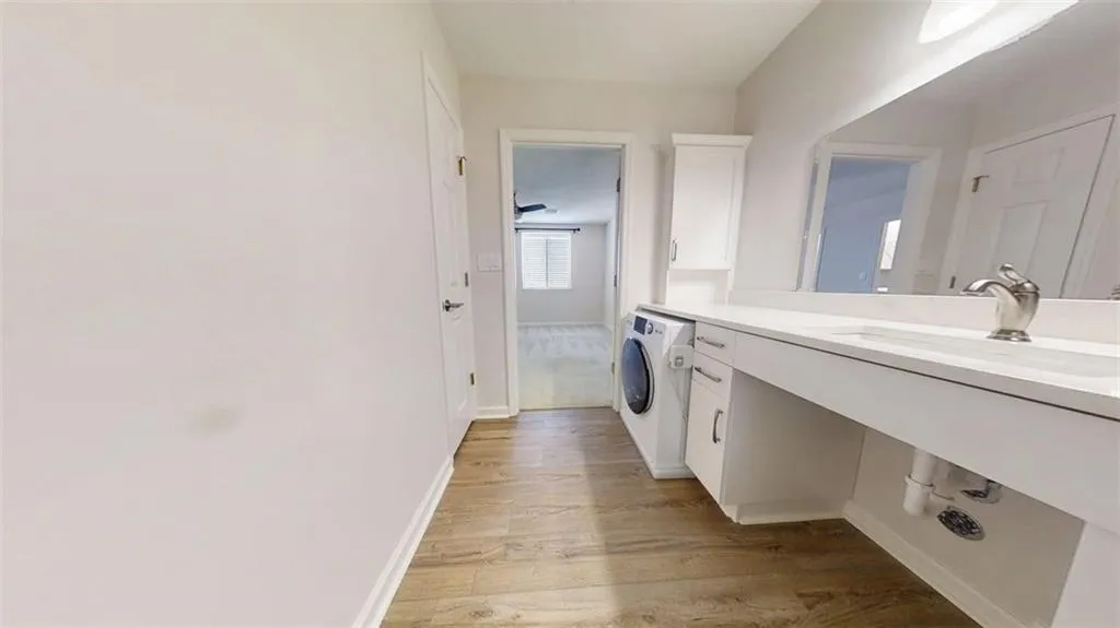 Laundry area with washer / dryer and light wood finished floors