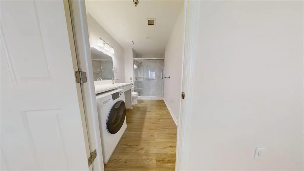 Washroom featuring washer / dryer and light wood-type flooring