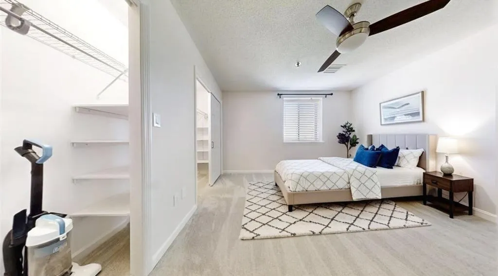 Bedroom with a textured ceiling and a ceiling fan