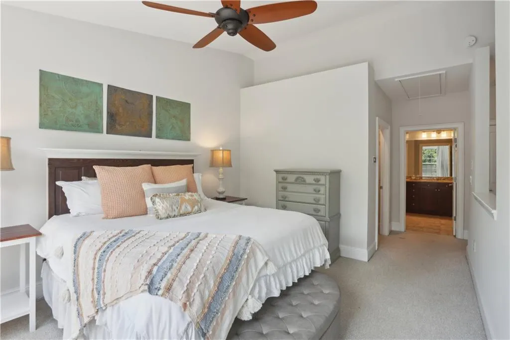 Bedroom with attic access, light carpet, and ceiling fan