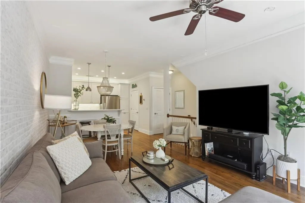 Living room with a ceiling fan, wood finished floors, recessed lighting, and ornamental molding