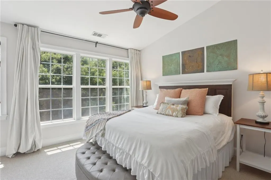 Carpeted bedroom featuring lofted ceiling and ceiling fan
