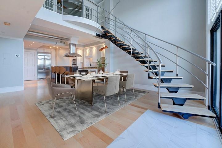 Dining space with light hardwood / wood-style flooring and a high ceiling