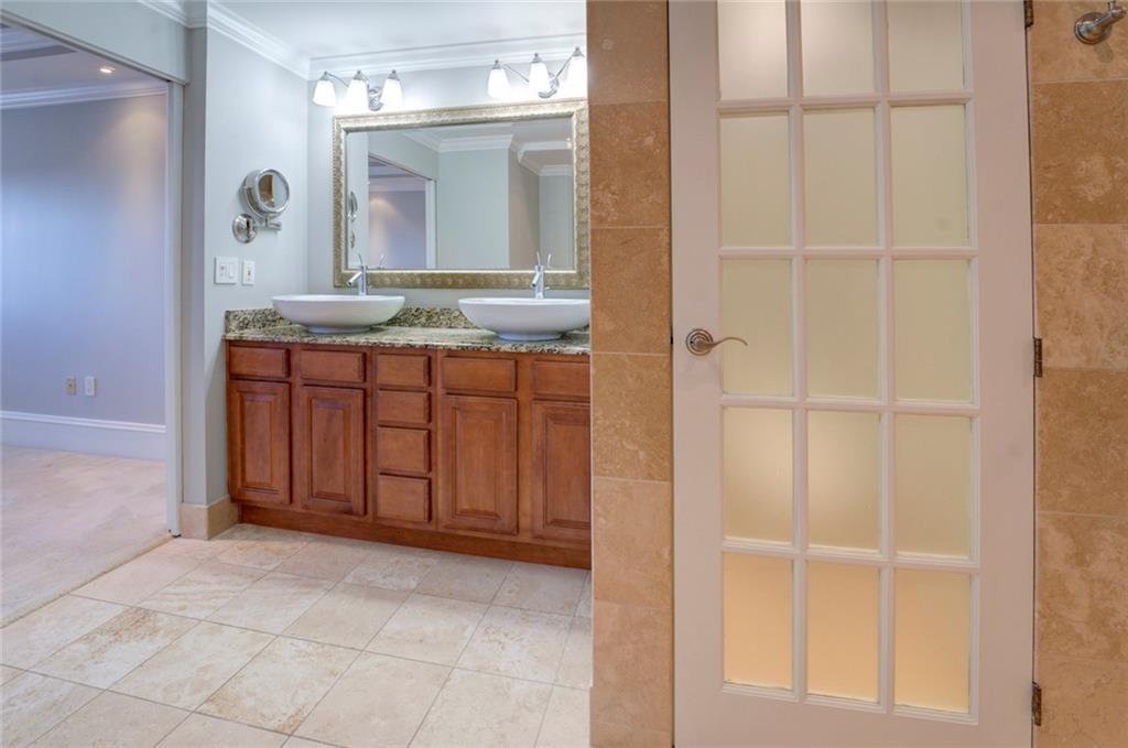 Bathroom with crown molding, large vanity, tile floors, double sink, and walk in shower