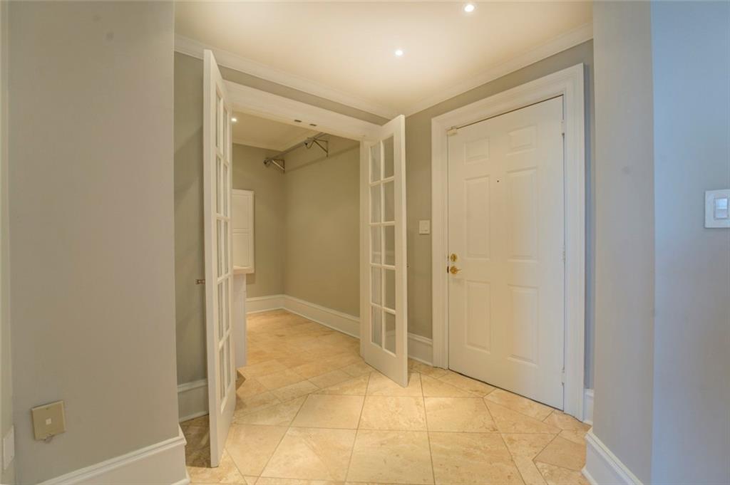 Corridor with ornamental molding and light tile floors