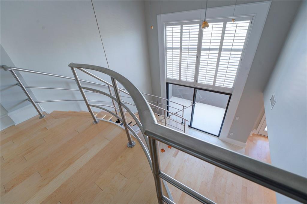 Staircase with a towering ceiling and light hardwood / wood-style flooring