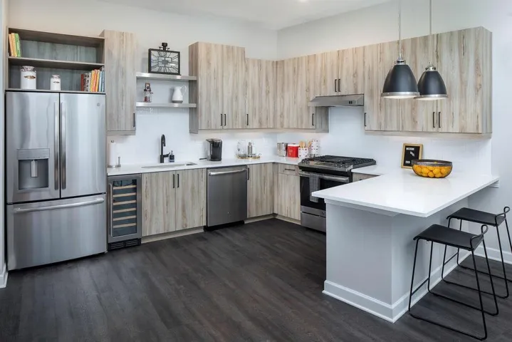 Kitchen with wine cooler, kitchen peninsula, sink, a breakfast bar, and appliances with stainless steel finishes