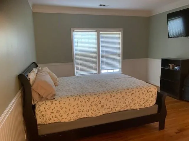 Bedroom featuring crown molding and hardwood / wood-style floors