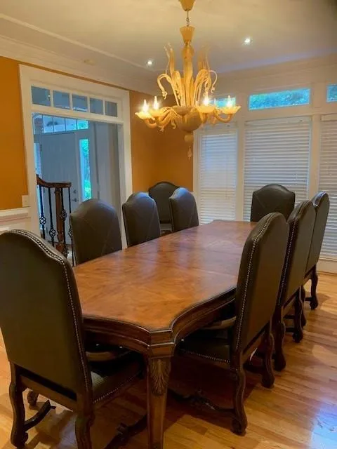 Dining space featuring crown molding, a notable chandelier, and light hardwood / wood-style flooring