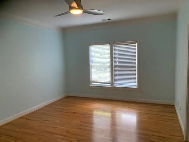 Unfurnished room featuring light hardwood / wood-style flooring, ceiling fan, and crown molding