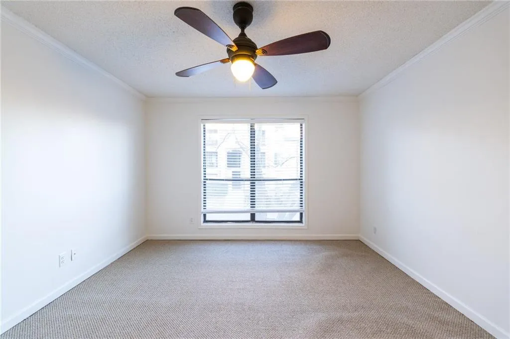 Unfurnished room featuring crown molding, baseboards, a textured ceiling, carpet flooring, and ceiling fan