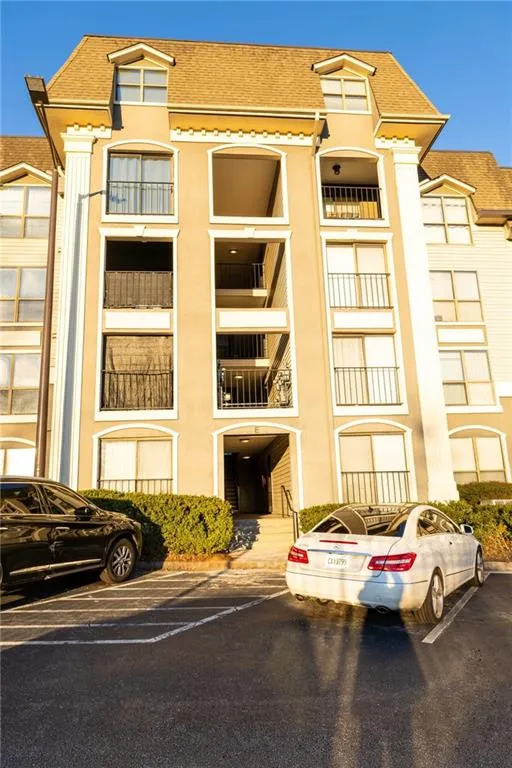 View of building exterior featuring uncovered parking