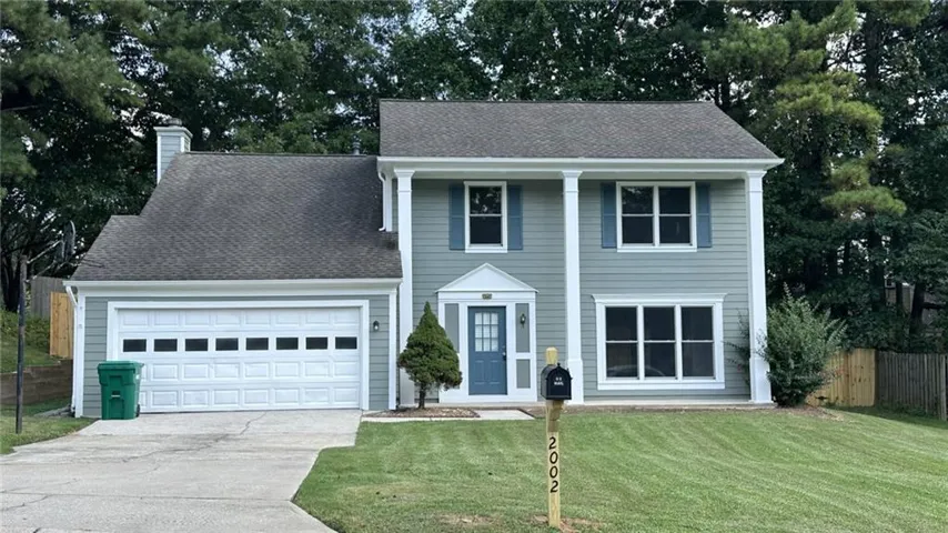 Two-story residence with a gray shingle roof, light blue siding, and white trim