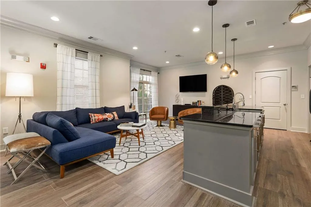 Living room featuring crown molding, light wood finished floors, and recessed lighting