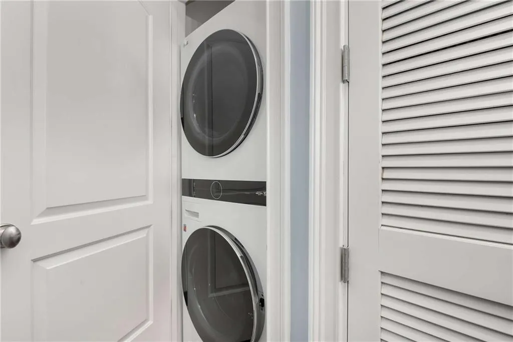 Washroom featuring stacked washer and clothes dryer