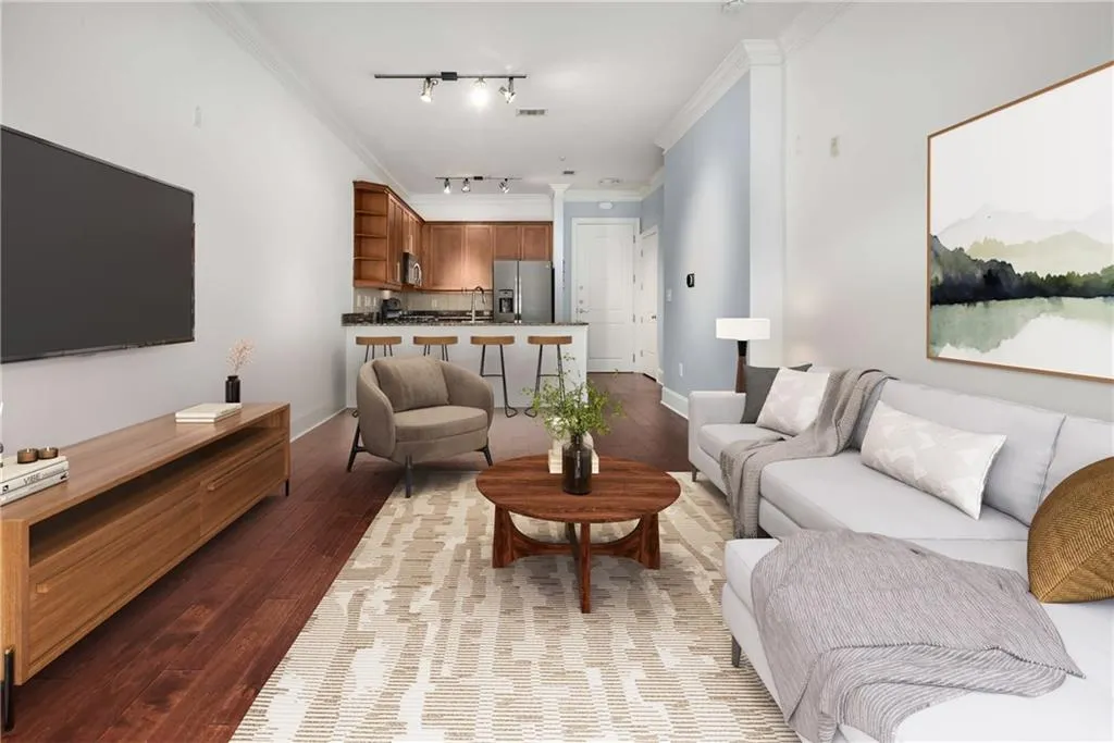 Living room featuring ornamental molding, wood finished floors, and track lighting