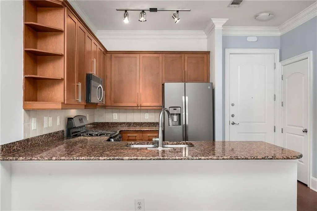 Kitchen featuring tasteful backsplash, open shelves, a peninsula, dark stone counters, and crown molding