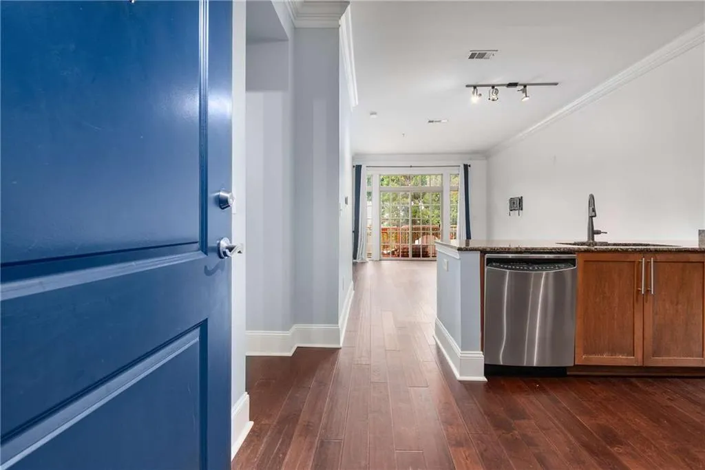 Hallway featuring ornamental molding, dark wood finished floors, and rail lighting