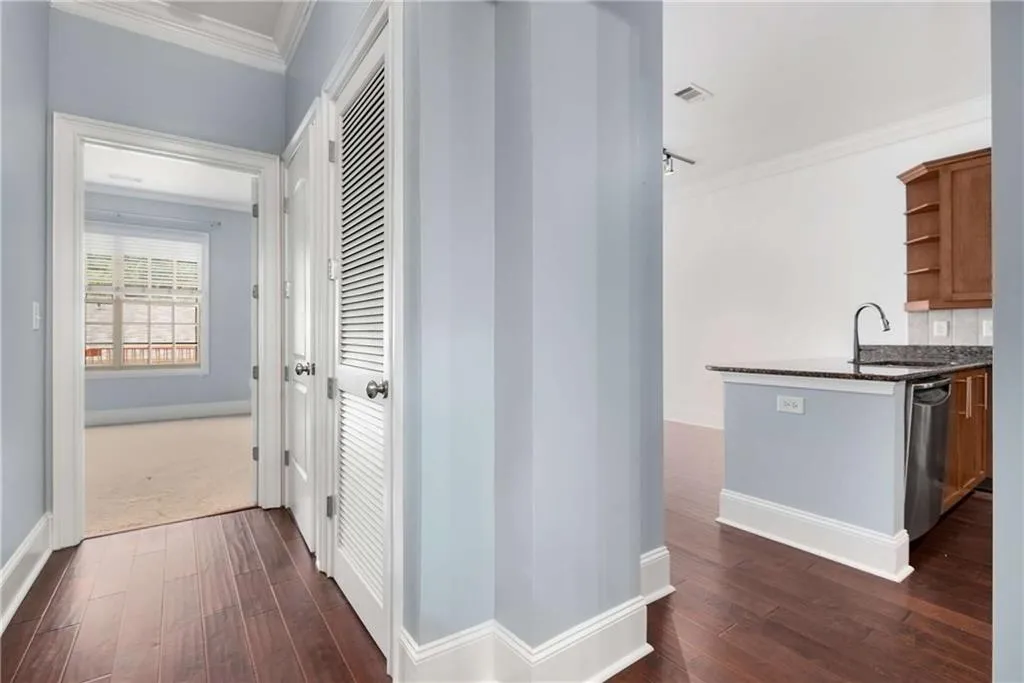 Hall featuring crown molding and dark wood-type flooring