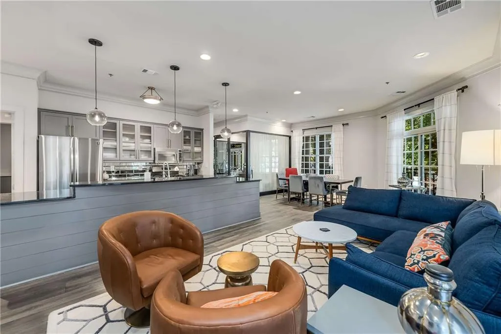 Living area with ornamental molding, wood finished floors, and recessed lighting