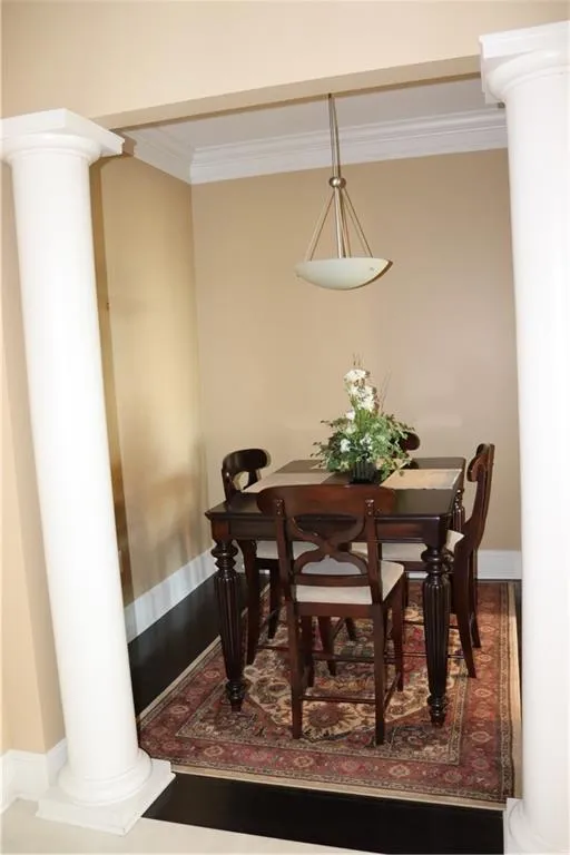 Dining area featuring decorative columns and ornamental molding