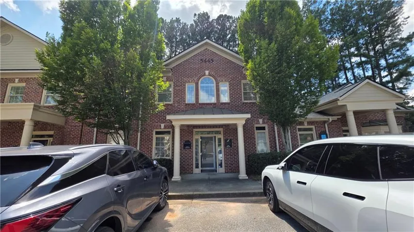 Brick facade building featuring multiple large windows and a covered entry