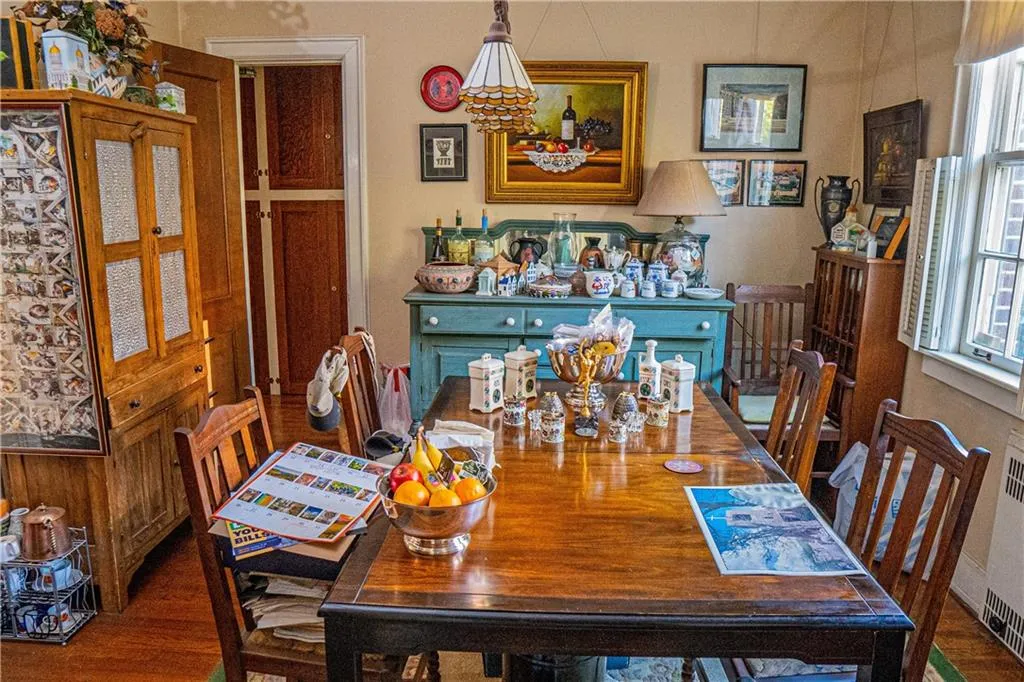 Dining space with wood finished floors and radiator heating unit