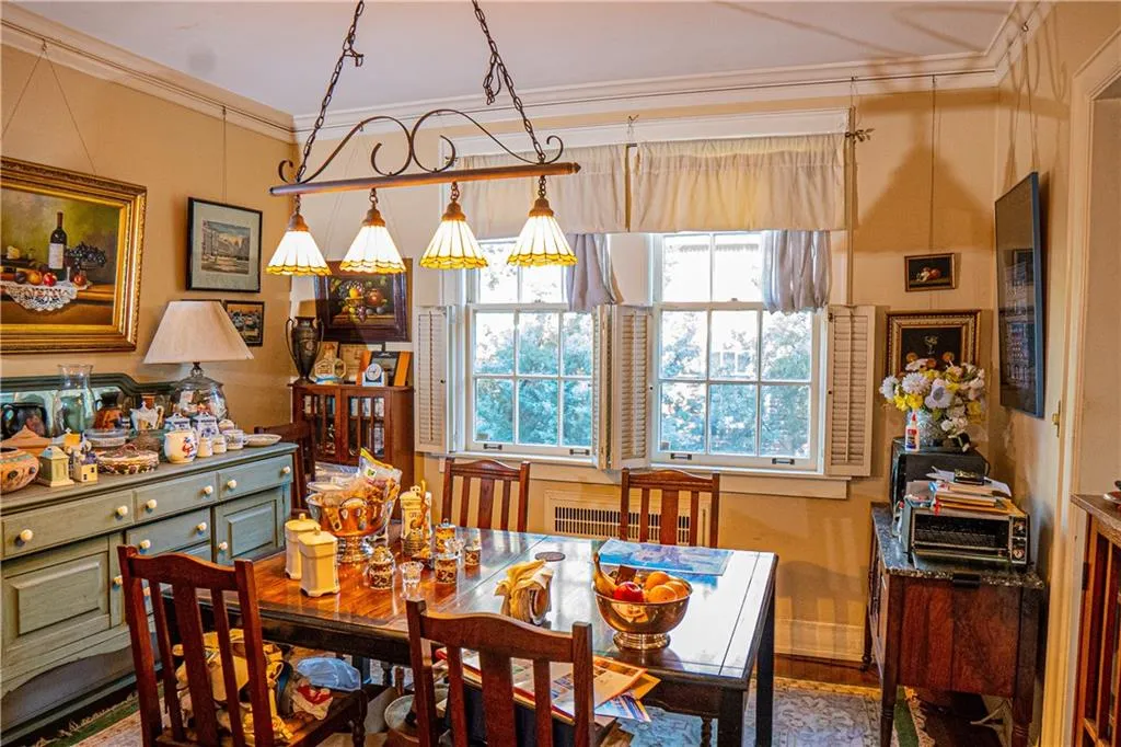 Dining area featuring crown molding, wood finished floors, and radiator heating unit